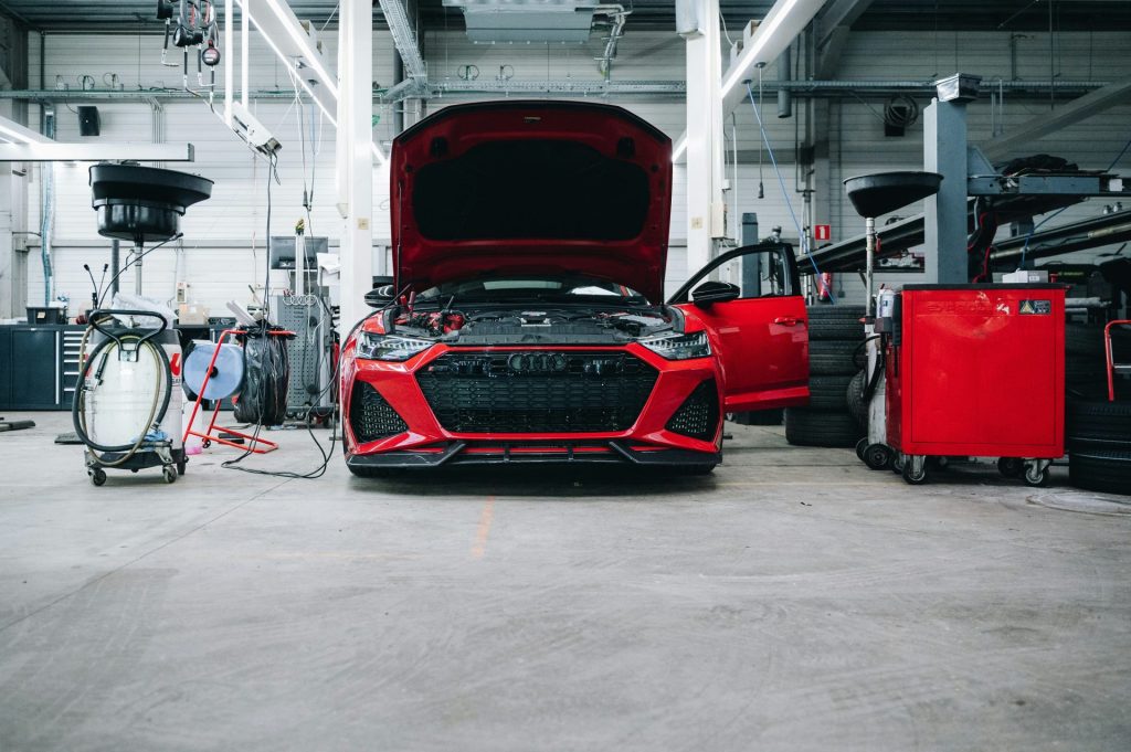 Ein rotes Auto befindet sich zur Reparatur in einer Werkstatt.
